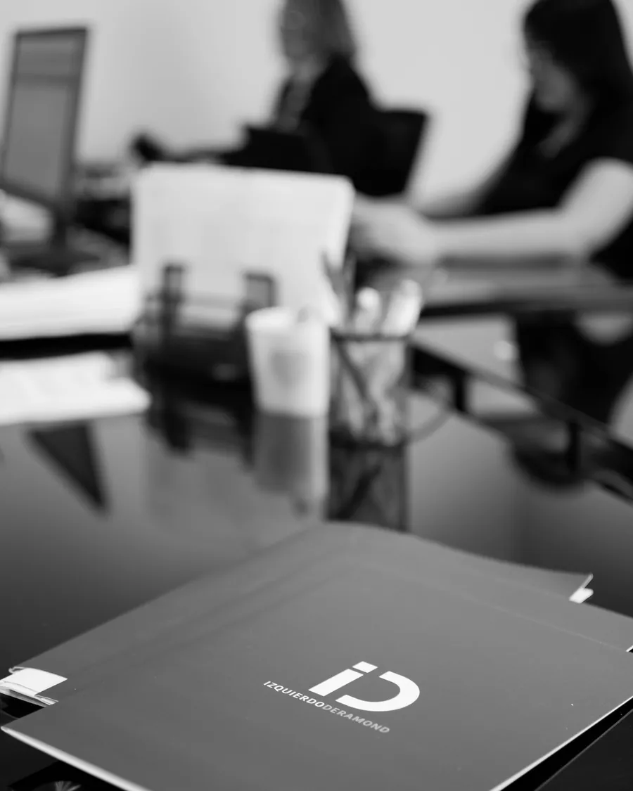 Detalle de carpeta corporativa Izquierdo Deramond Consultores en sala de reuniones